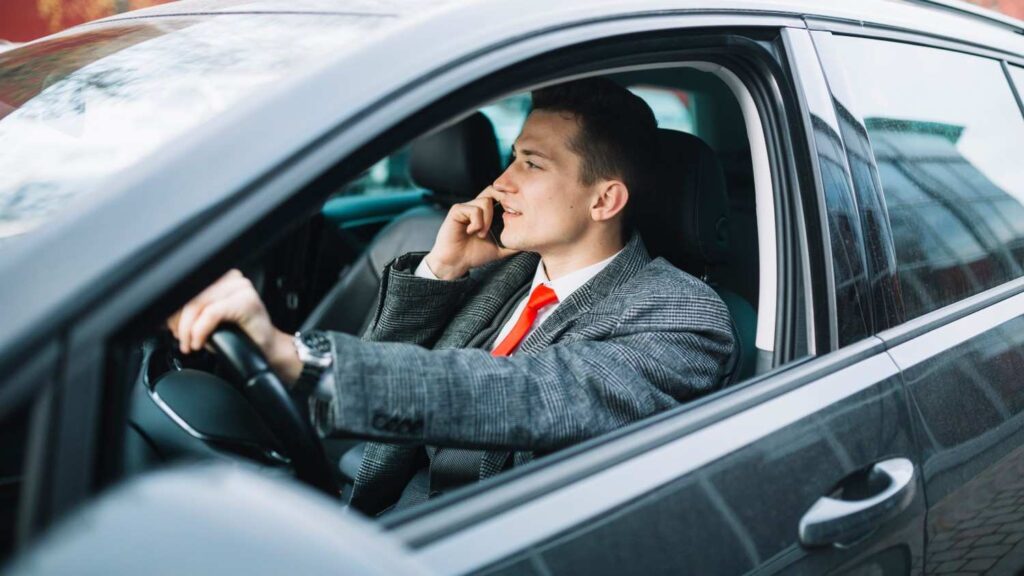 Professional chauffeur answering a passenger call to arrange a fast pickup for a taxi near me booking.