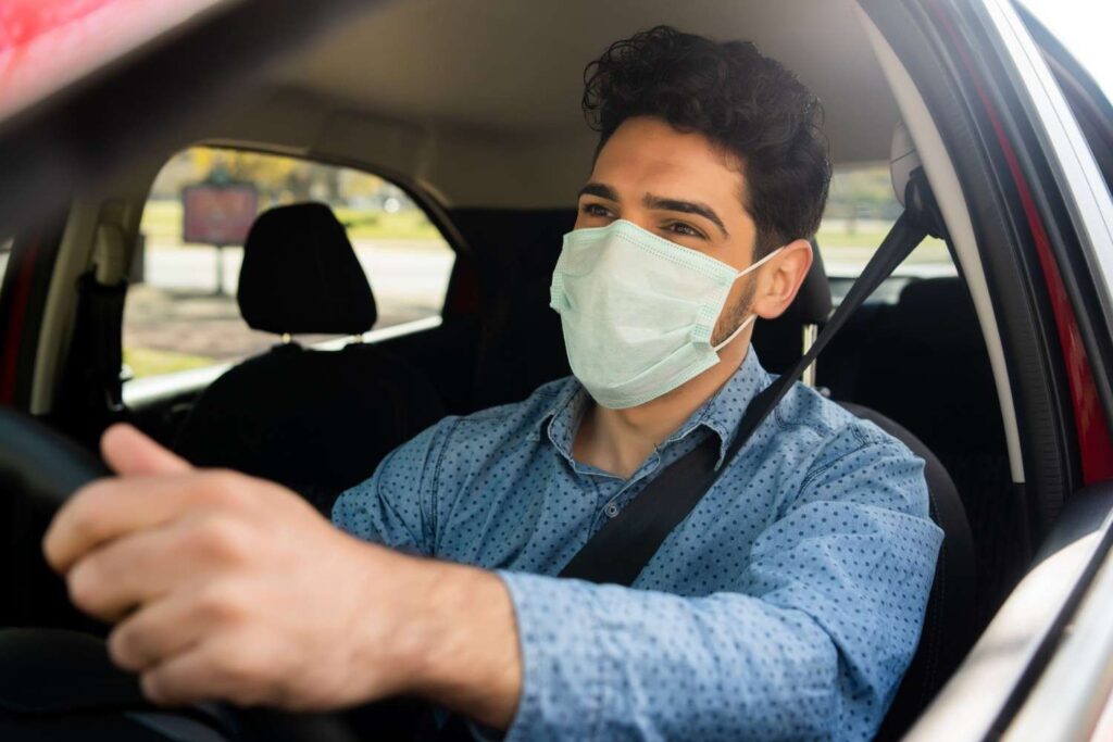 Professional driver wearing a protective mask providing safe and sanitized taxi stony plain services.