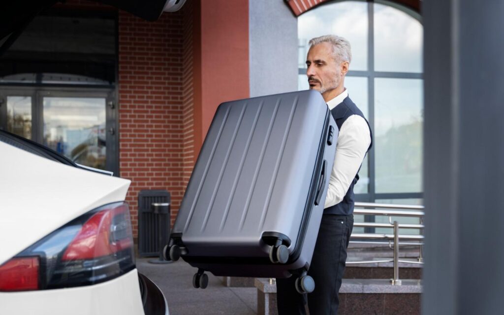 Professional driver assisting with heavy luggage for a seamless airport taxi transfer in Stony Plain.
