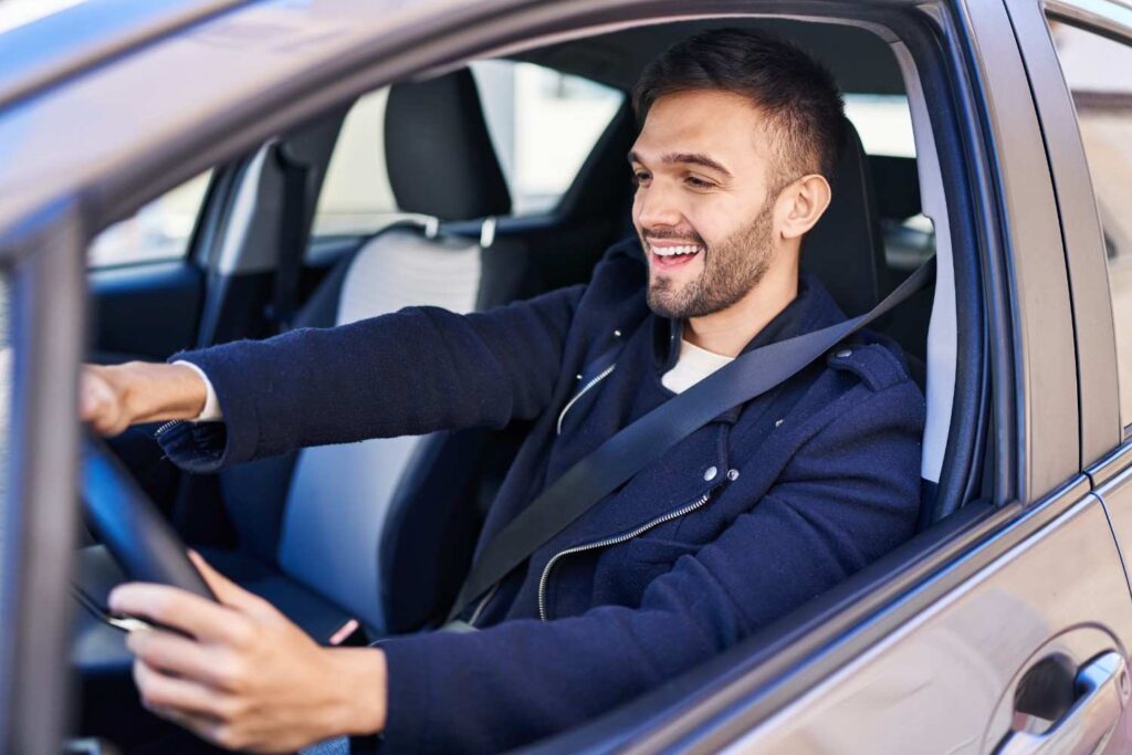 A friendly, smiling driver behind the wheel providing professional taxi stony plain services and answering local travel questions.